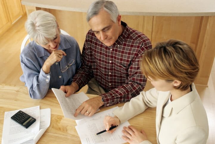 Conseillère en gestion de patrimoine présentant un bilan de retraite personnalisé à un couple